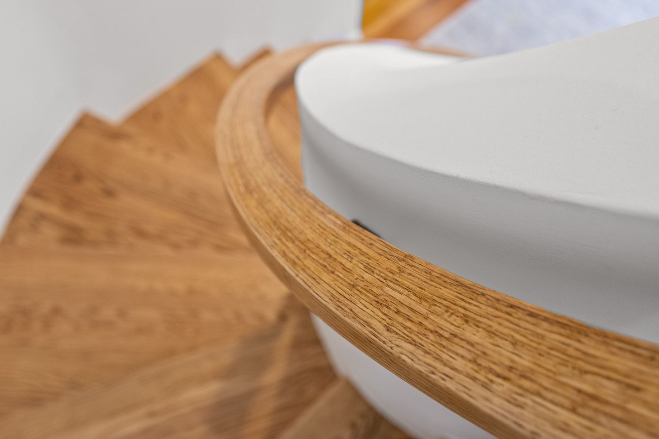 Custom curved staircase detail in oak and plaster