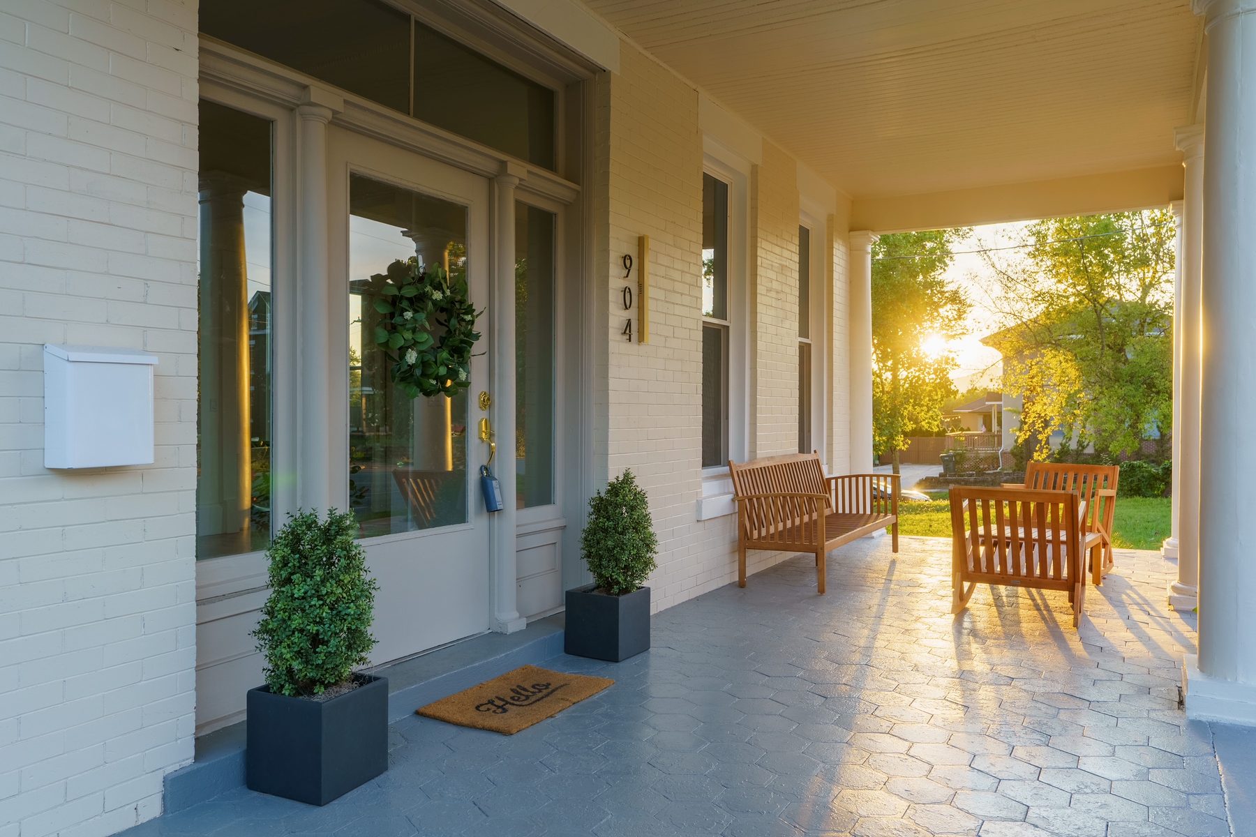 Porch of the restored 904 East Martin Luther King Boulevard home in golden evening light