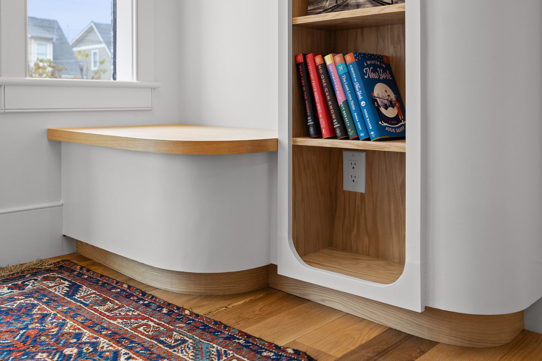 Built-in oak window seat and shelving detail in the library