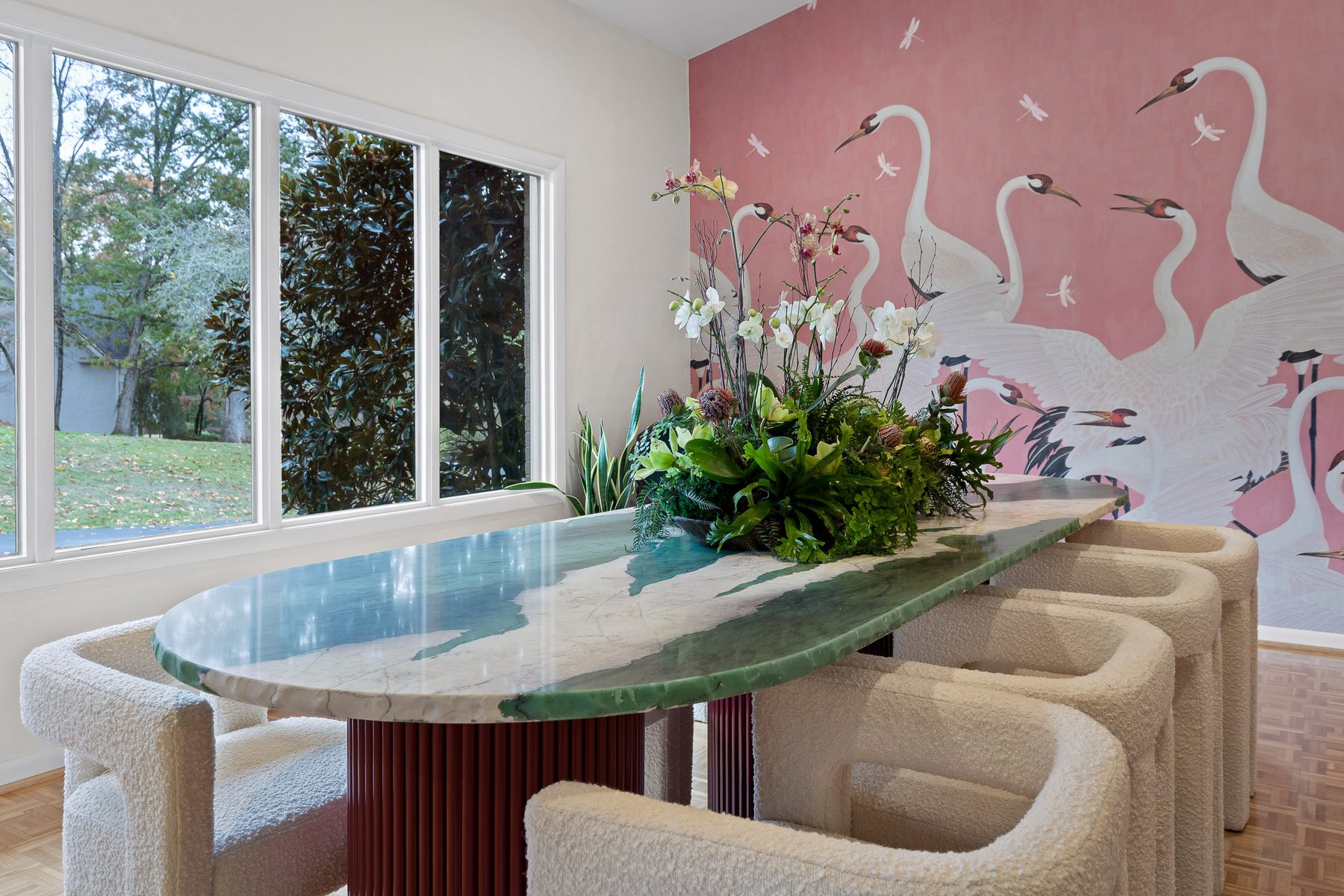 Sculptural plaster and green glass table with curved seating in a vaulted room