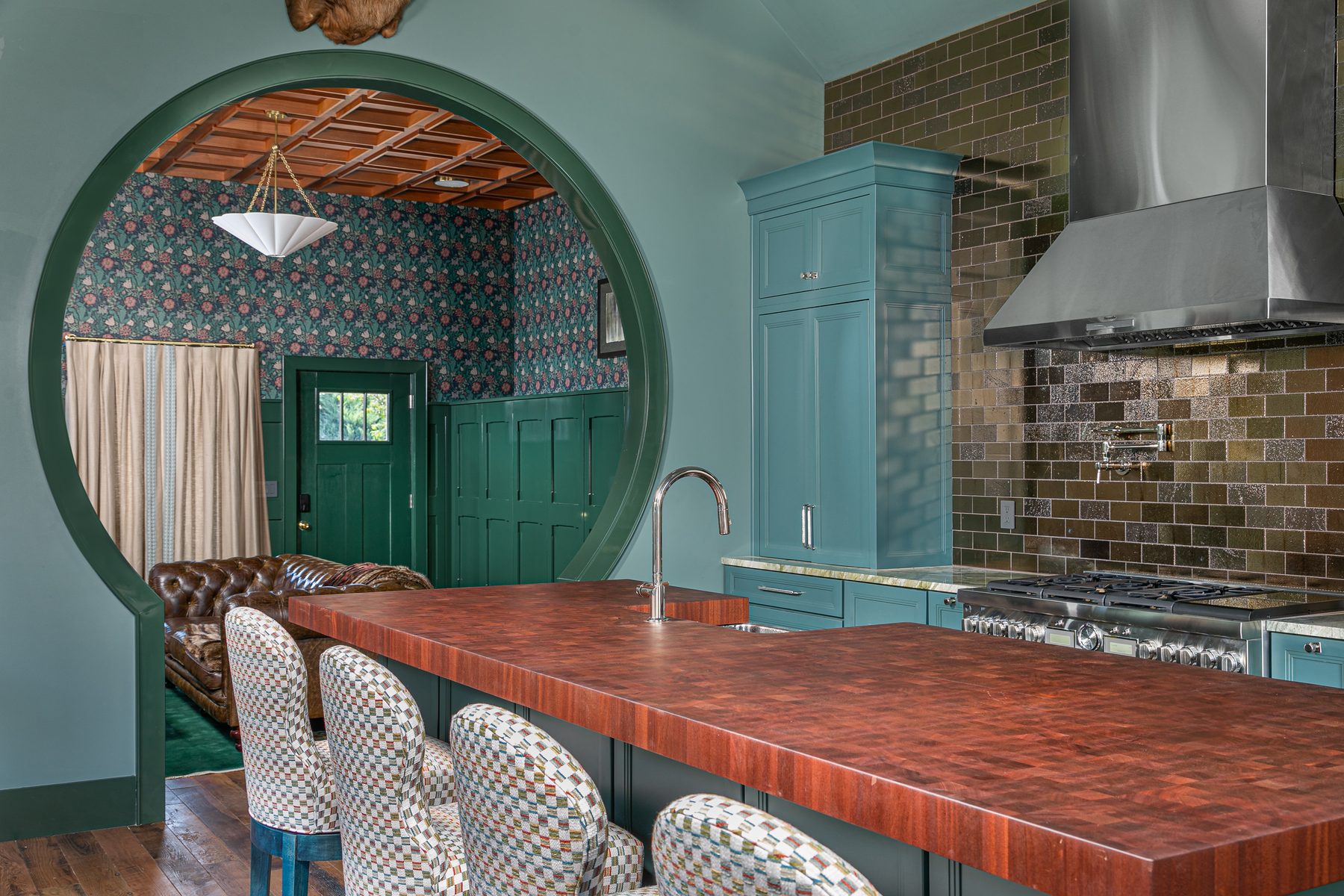 Kitchen detail with a copper countertop, porthole window, and black range hood